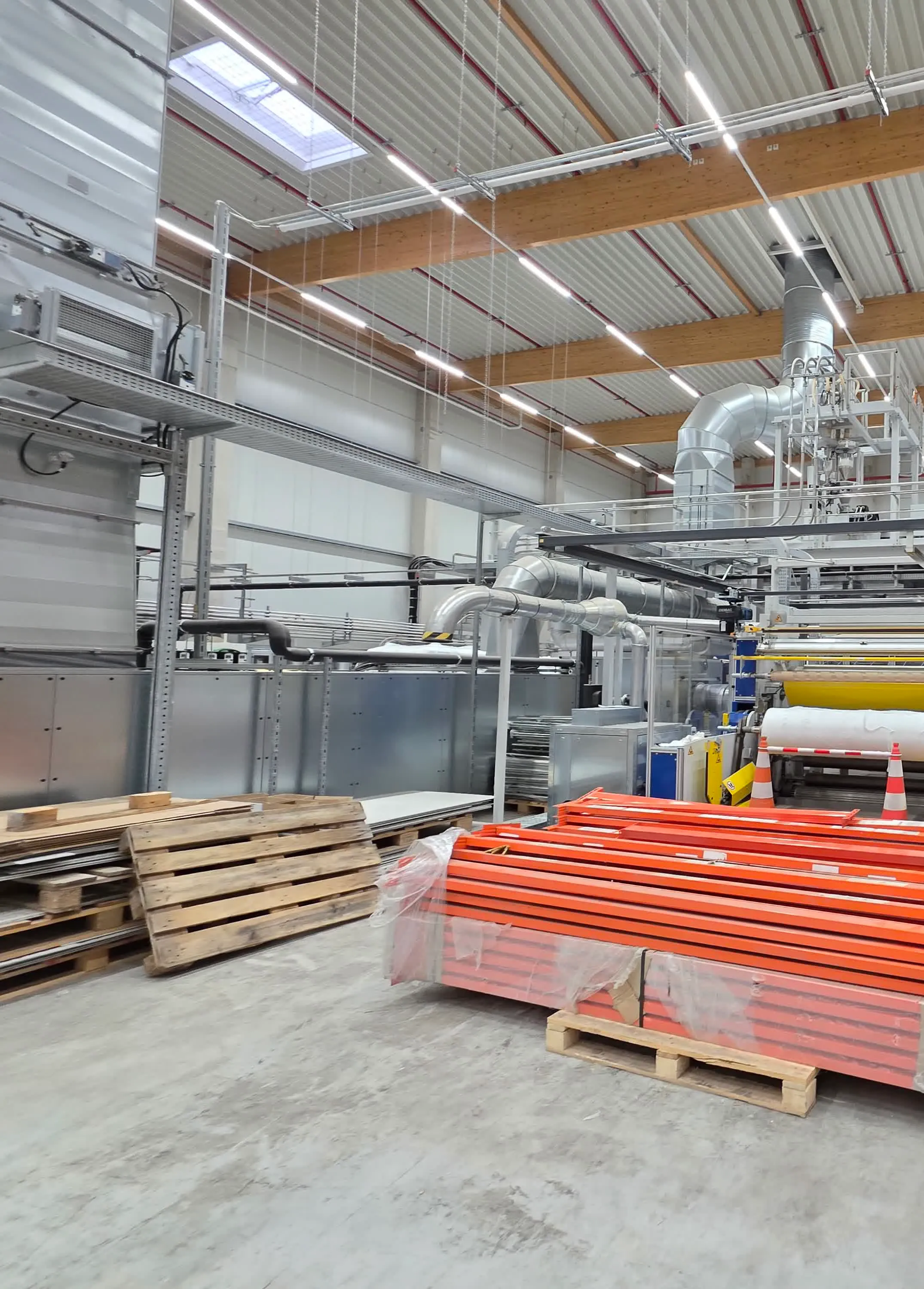 Extrusion line viewed from the packaging area, with die head and take-up rolls