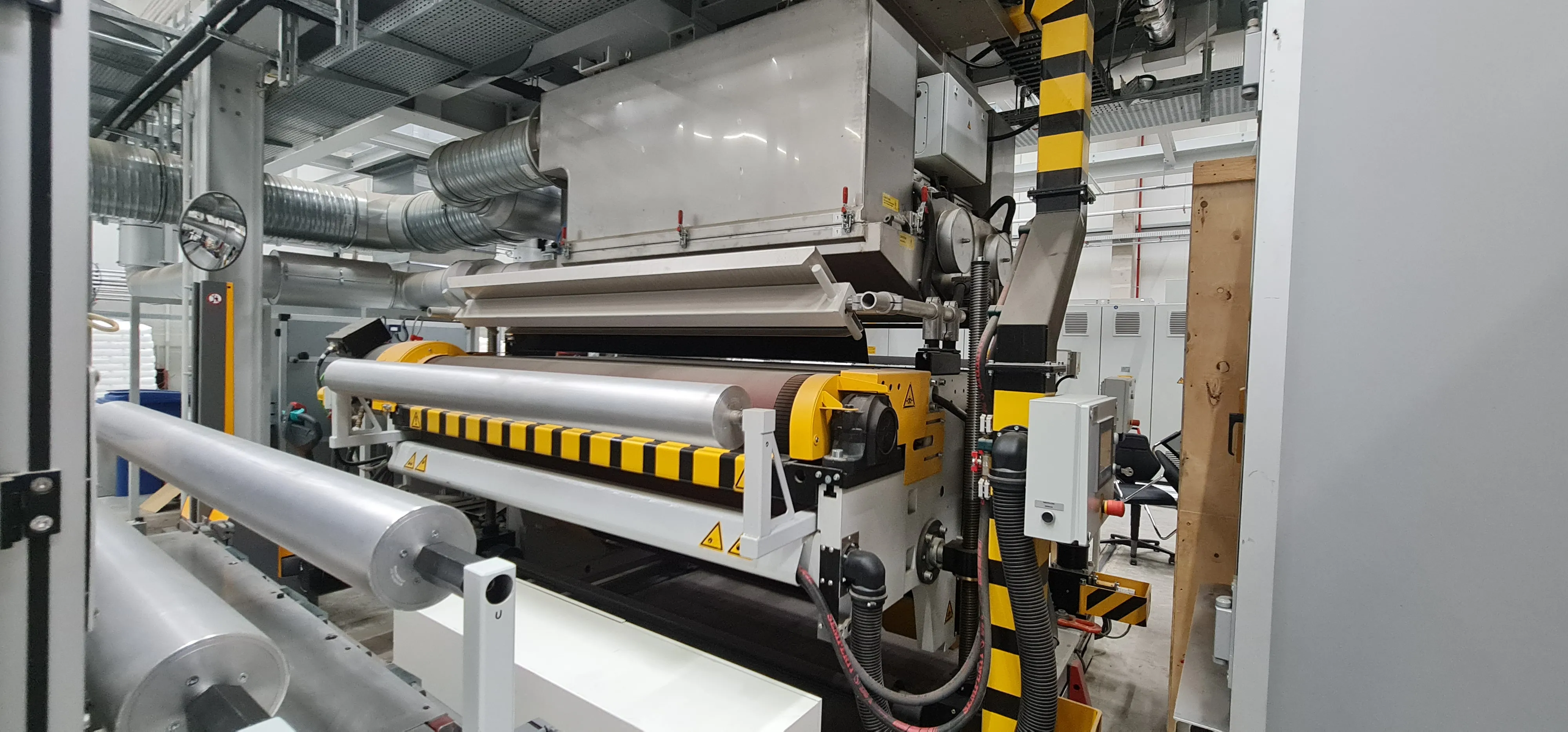 Forming rollers with yellow safety guards beneath the die