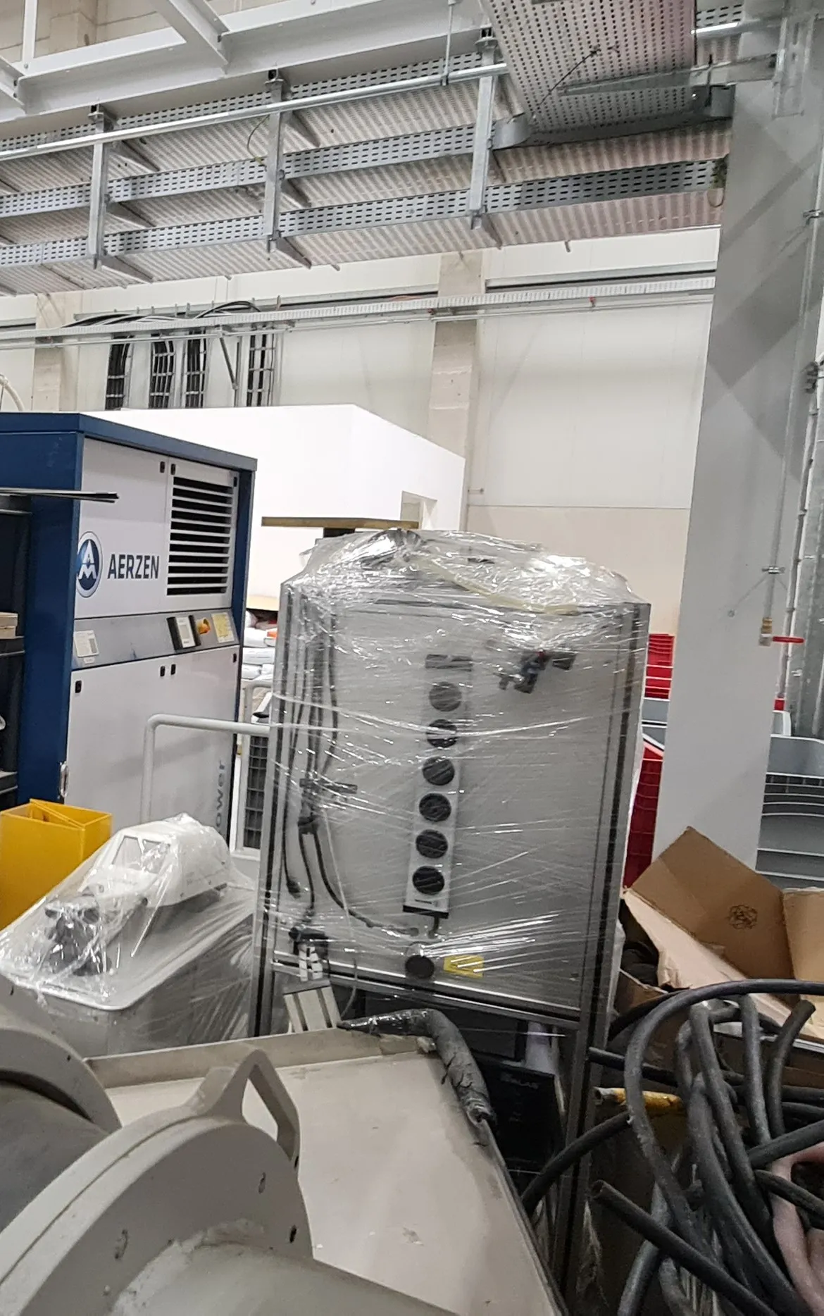 Aerzen blower and a wrapped control cabinet in storage