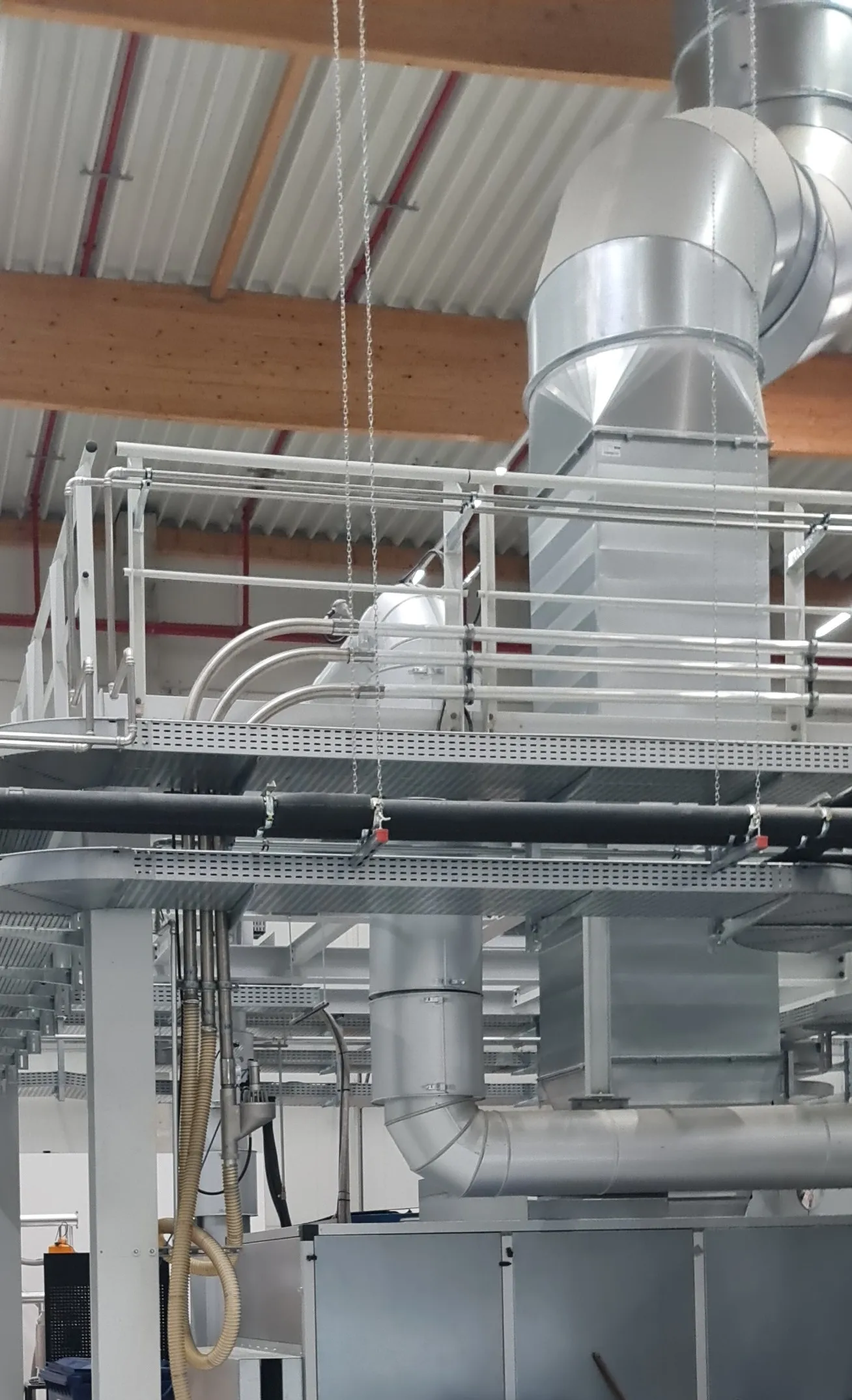 Platform with material conveying lines and ducting above the Berliner Luft air handling units